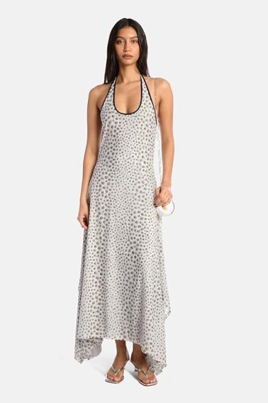 Kate Barton Stella Maxi Handkerchief Dress $495 FREE Returns Woman in a halter neck dress with a dotted pattern and asymmetrical hemline.